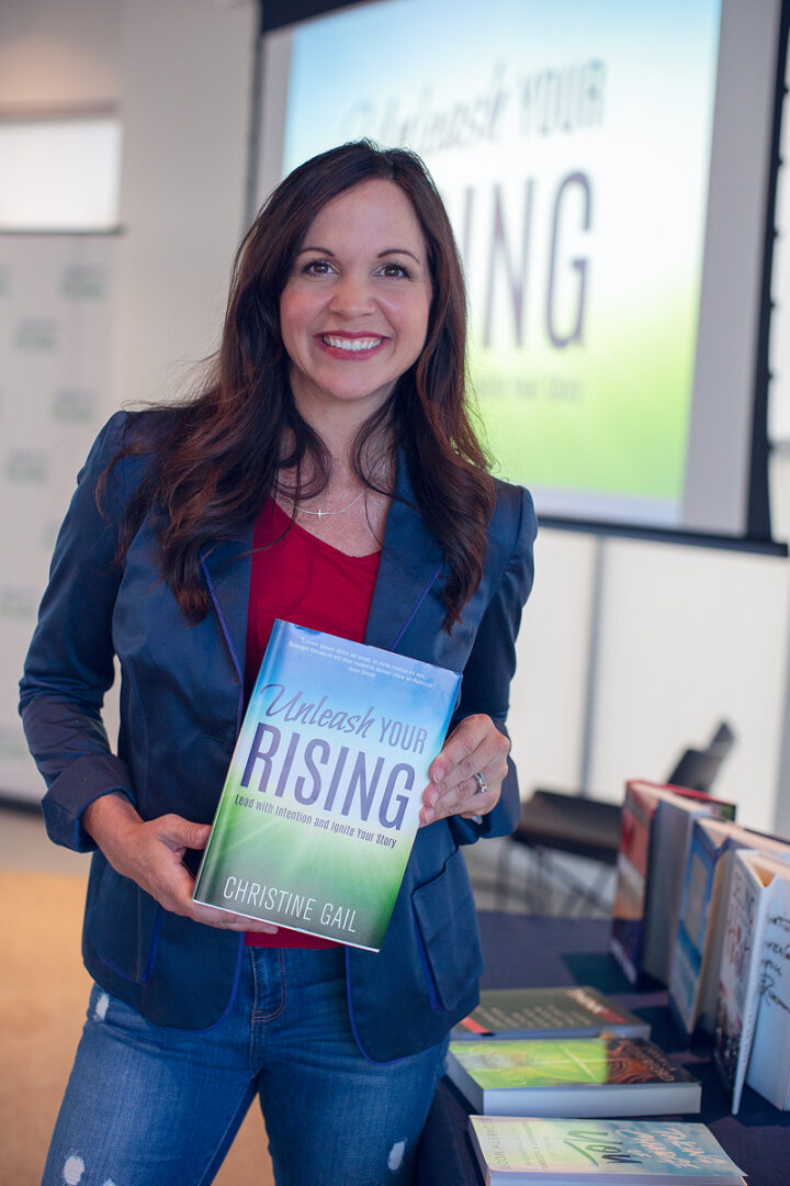 A woman holding up a book in front of a group.