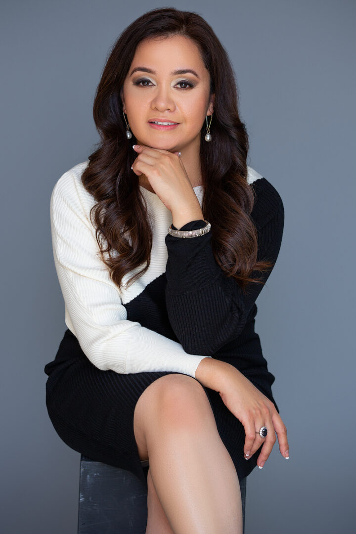 A woman sitting on the ground wearing black and white.