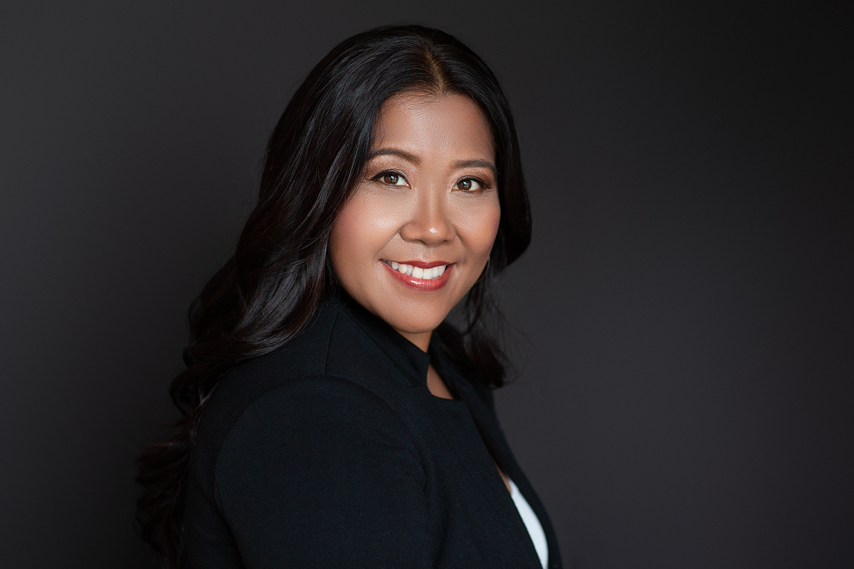 A woman in black jacket smiling for the camera.