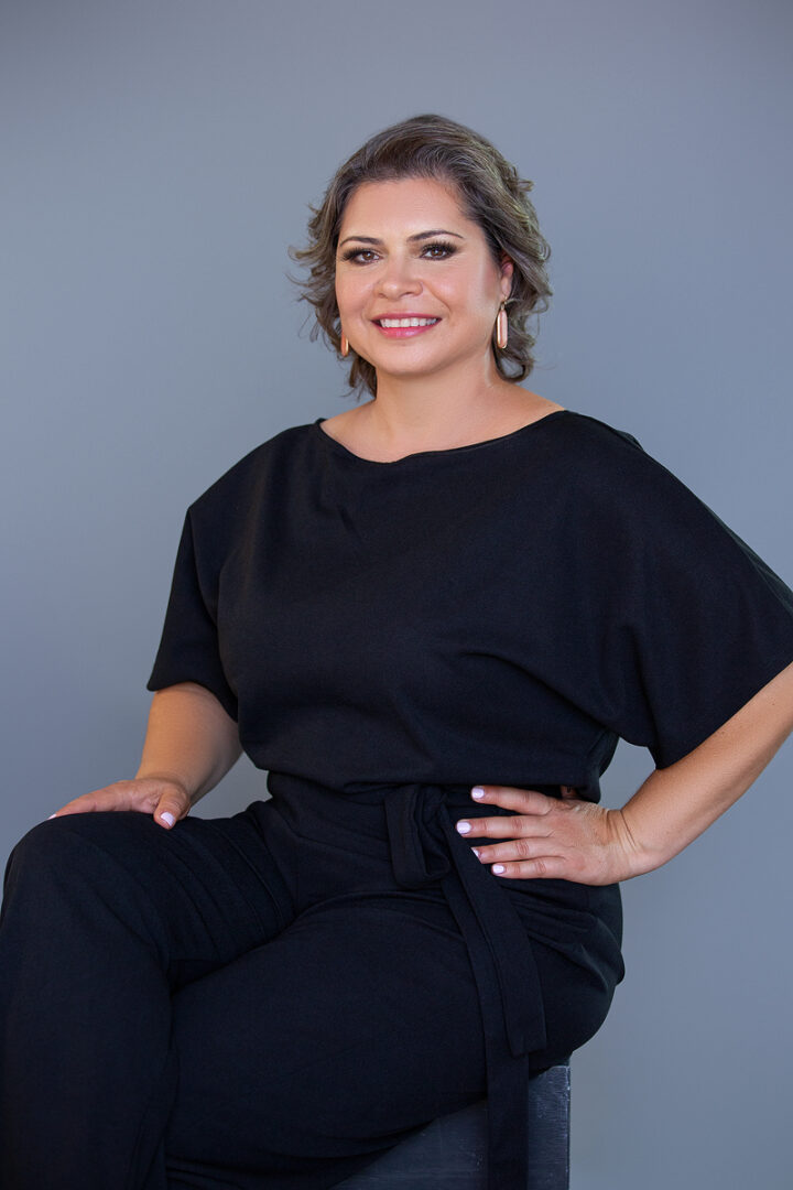 A woman in black shirt and pants posing for the camera.