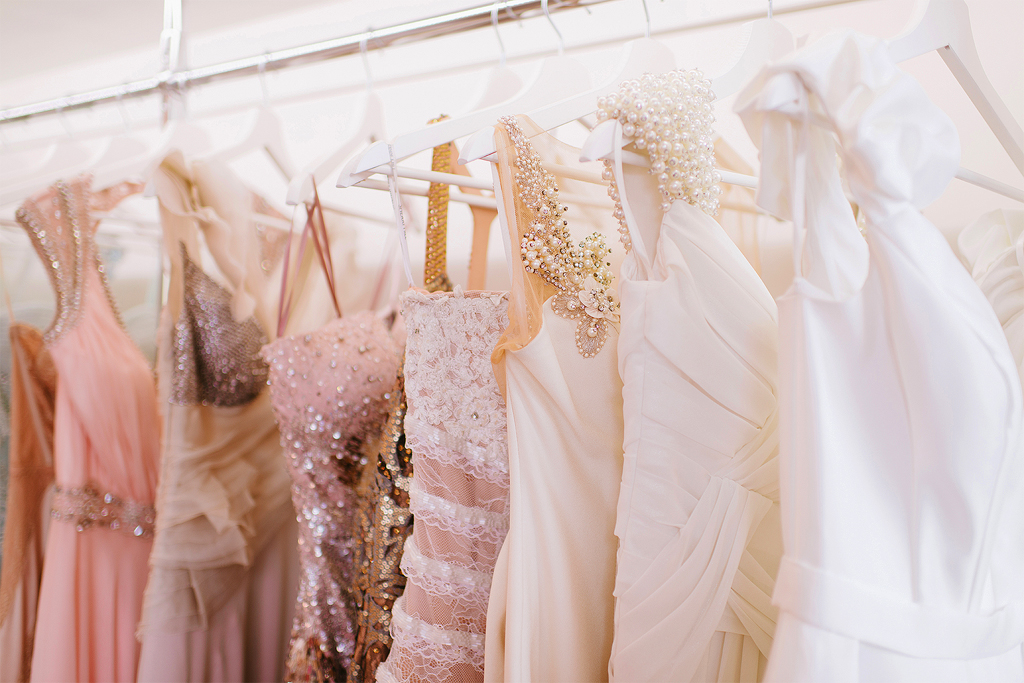 A row of dresses hanging on the rack.