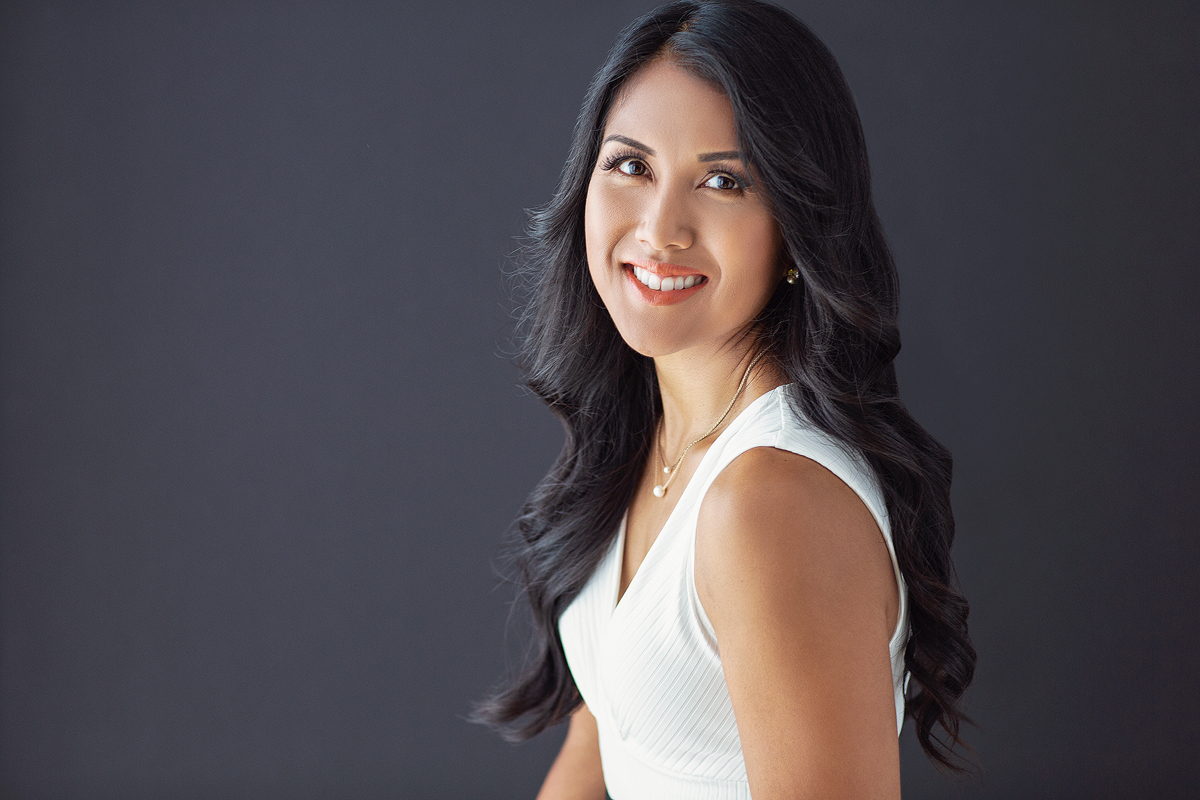 A woman with long black hair wearing white.