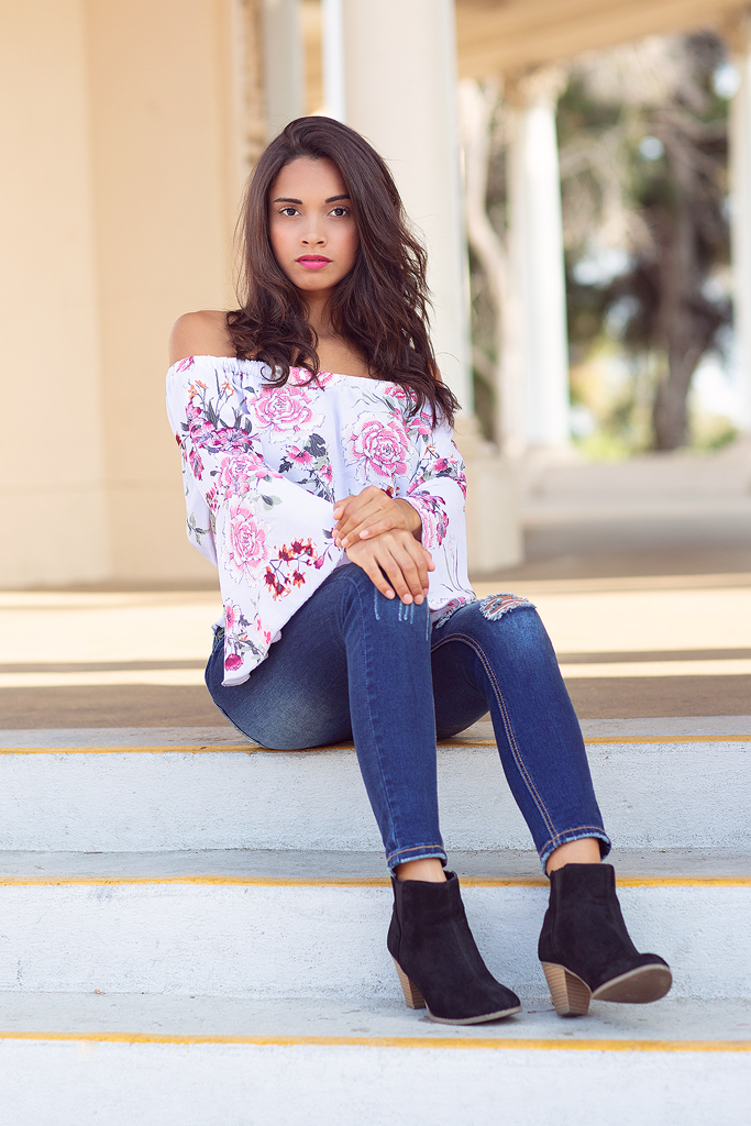 A woman sitting on steps wearing black boots.