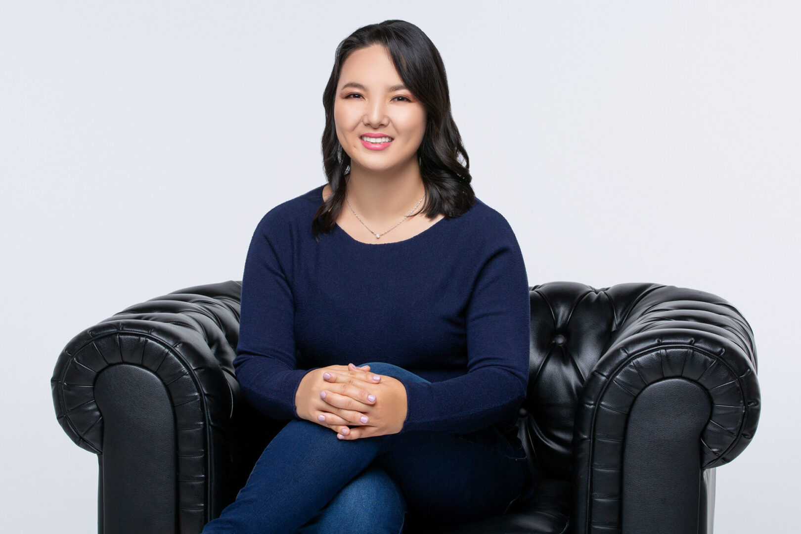 A woman sitting on top of a black chair.